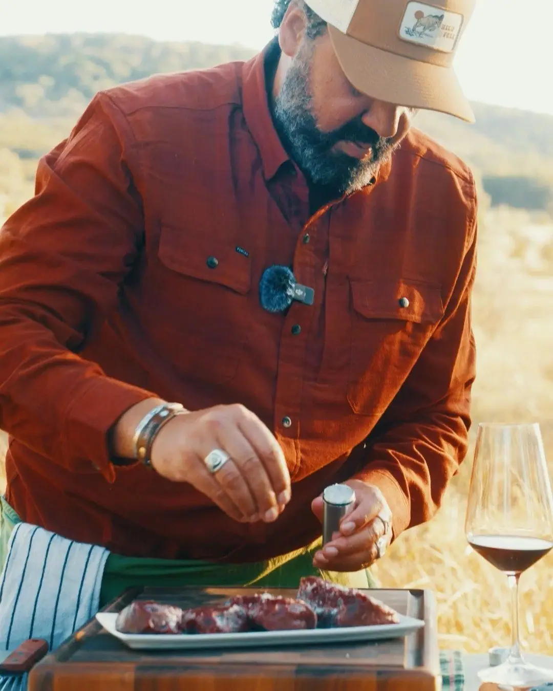 Josh Crumpton seasoning wild game beside a glass of red wine